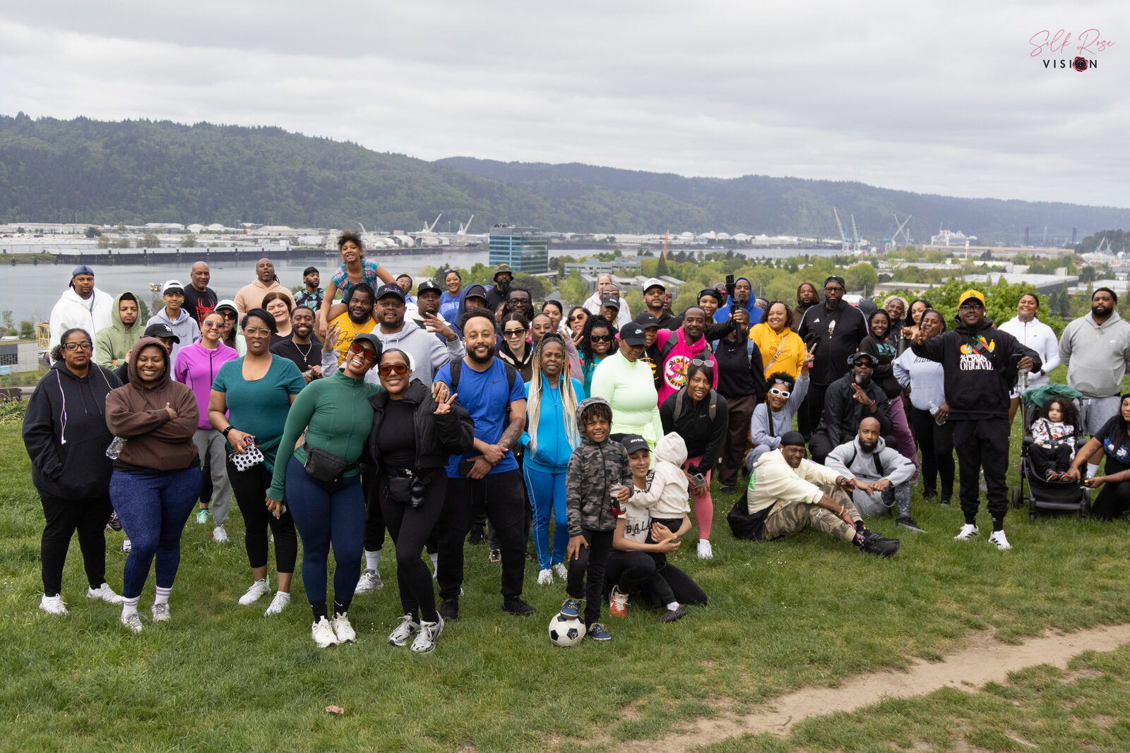 Large group photo at a park overlooking the river