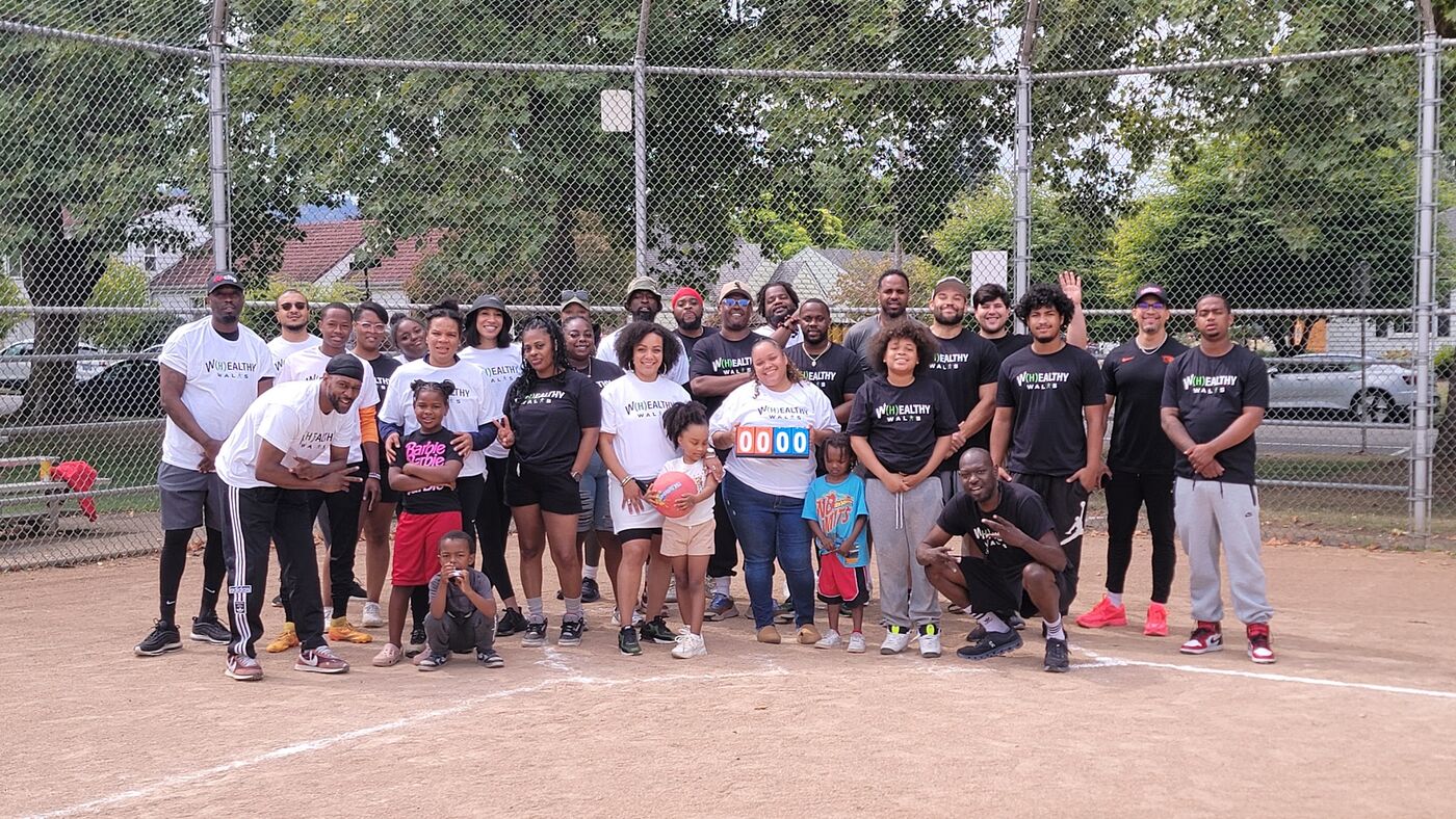 Group in W(H)ealthy Walks shirts on a baseball field