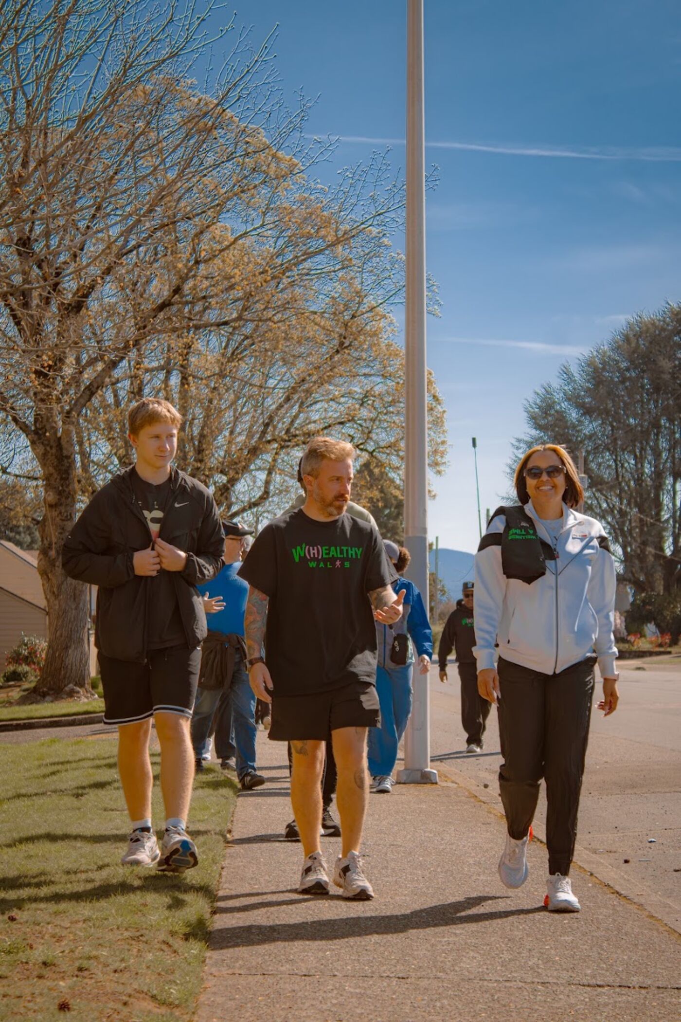 Three walkers on a sidewalk