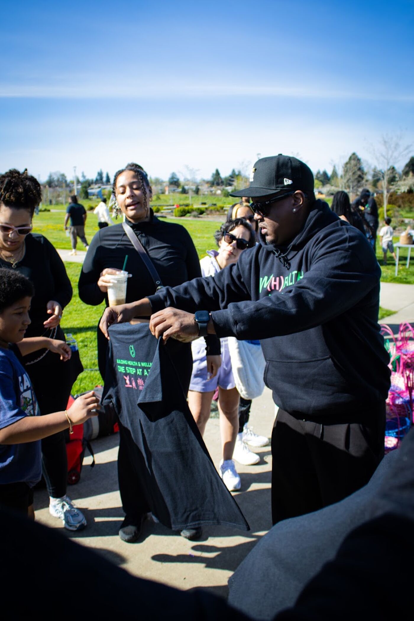 Volunteer handing out a W(H)ealthy Walks t-shirt